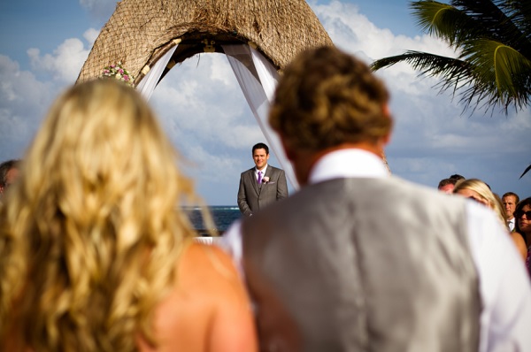 Groom waiting under palapa at Dreams Riviera Cancun for his bride