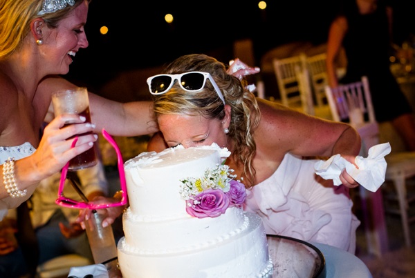 Bridesmaid sticks her head into wedding cake, destination wedding