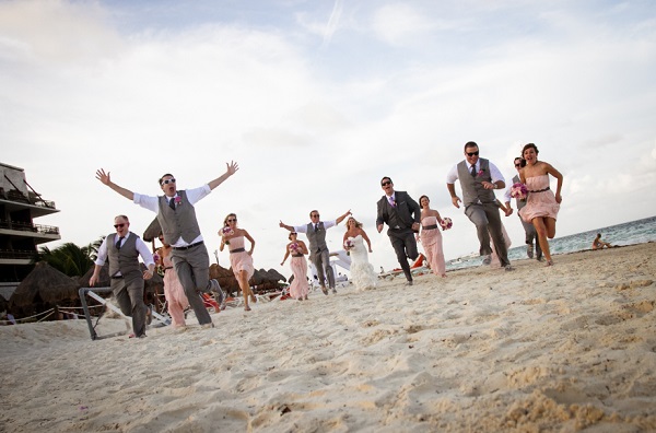 Destination Wedding party running on the beach, pink dresses, grey suits, Dreams Riviera Cancun