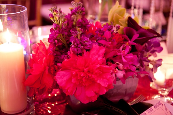 Gorgeous pink and purple flower centrepieces with hurrican candles and tea lights